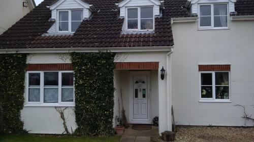 a white house with a white door and ivy at Hethersett Lodge in Norwich