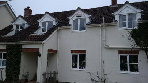 a white house with white windows and a roof at Hethersett Lodge in Norwich