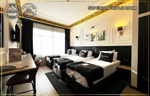 a hotel room with four beds and a desk at Angel's Home Suites - Angel Group Hotels in Istanbul