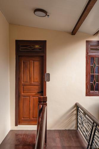 a wooden door in a room with a staircase at Penang Story LINN House in George Town