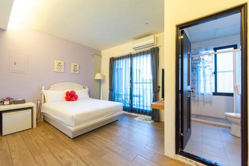a bedroom with a bed with a red flower on it at Ting Shuan B B&B in Suao