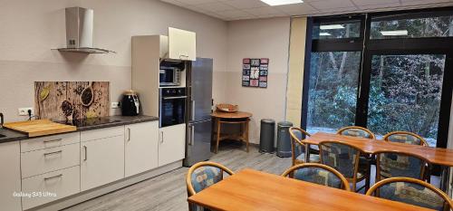 a kitchen and dining room with a table and chairs at Aparthotel Höper in Oyten