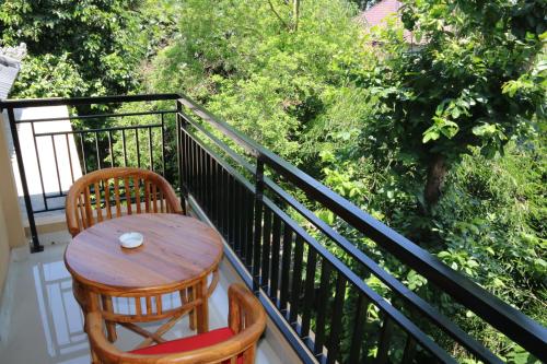 a wooden table and two chairs on a balcony at Guesthouse Gusti Putu Oka in Ubud