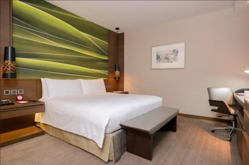 a hotel room with a bed and a desk and a computer at Marco Polo Ortigas Manila in Manila