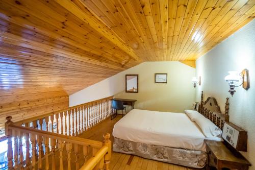 a bedroom with a bed and a wooden ceiling at Abba Ordino Babot Hotel in Ordino