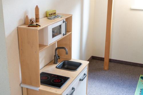a small kitchen with a sink and a microwave at Schlafen zur Brauerei St. Johann in Nesslau