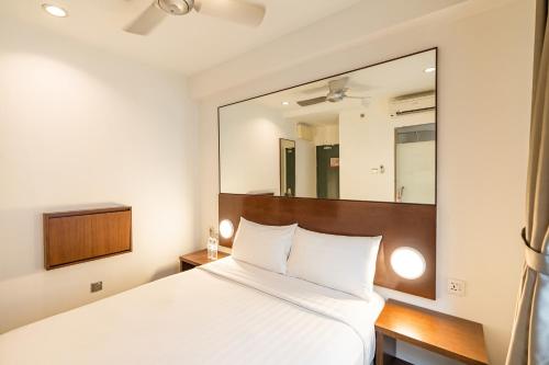 a bedroom with a white bed and a large mirror at Tune Hotel Georgetown Penang in George Town