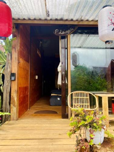 a porch of a house with a table and a chair at Đồi Gió Hú Homestay & Coffee Măng Đen in Kon Von Kla