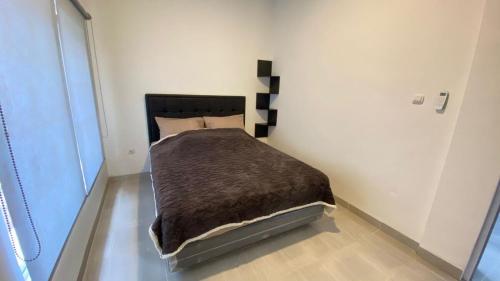 a bedroom with a bed with a brown blanket at Asaan homestay in Ciburial