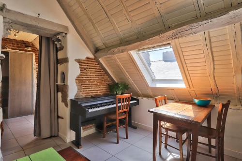 Cette chambre dispose d'un piano et d'une table avec des chaises. dans l'établissement T1 bis charmant Place Graslin, à Nantes