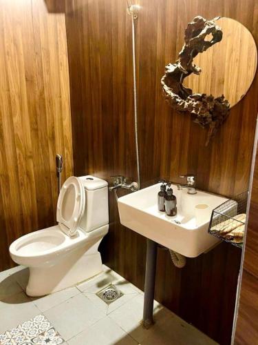 a bathroom with a toilet and a sink at Đồi Gió Hú Homestay & Coffee Măng Đen in Kon Von Kla
