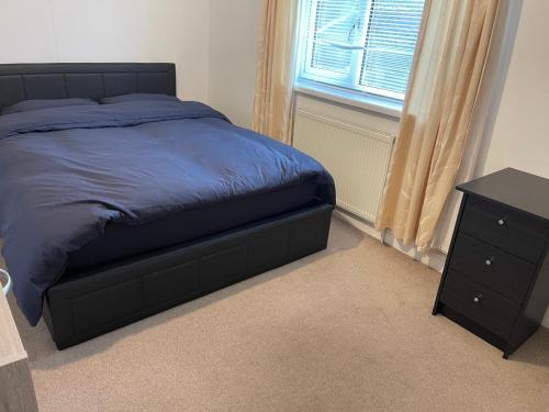 a bedroom with a bed and a dresser and a window at Lodge Park - 2 minutes walk to Stoke Hospital in Stoke on Trent