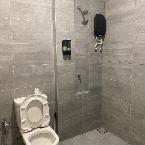a bathroom with a toilet and a phone on the wall at LeStarry Homestay in Kuching