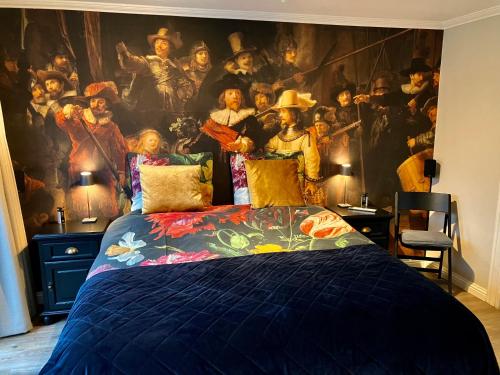 a bedroom with a large painting on the wall at Voorsterstaete former barn, including jacuzzi in Voorst