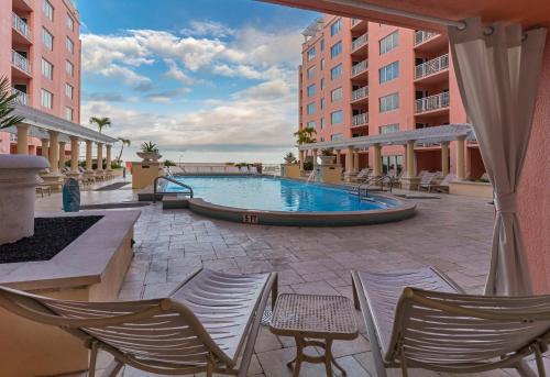 a patio with chairs and a swimming pool at Hyatt Regency Clearwater Beach Resort & Spa in Clearwater Beach