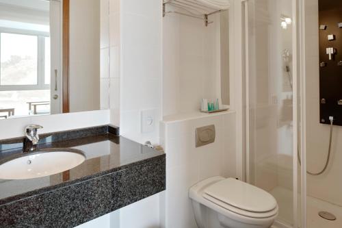 a bathroom with a toilet and a sink and a shower at Saiaz Getaria Hotela in Getaria
