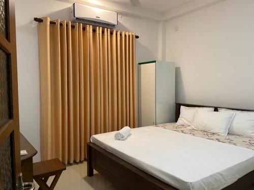 a bedroom with a bed and a curtain at Labuduwa Rest in Galle
