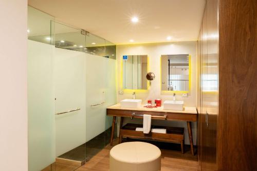 a bathroom with a sink and a mirror at The Fives Downtown Hotel & Residences, Curio Collection by Hilton in Playa del Carmen