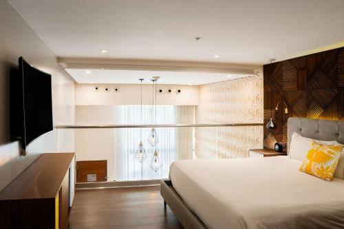 a bedroom with a large bed and a window at The Fives Downtown Hotel & Residences, Curio Collection by Hilton in Playa del Carmen