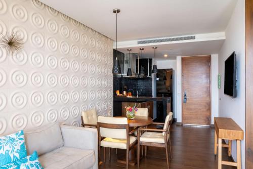 a living room and dining room with a table and chairs at The Fives Downtown Hotel & Residences, Curio Collection by Hilton in Playa del Carmen