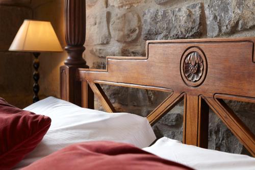 a bed with a wooden head board in a room at Saiaz Getaria Hotela in Getaria