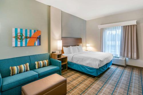 スポケーンにあるMainStay Suites Spokane Airportのベッドとソファのあるホテルの部屋