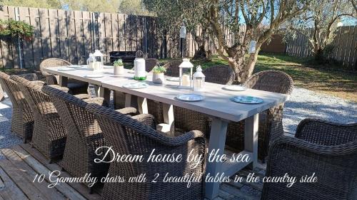 a table with wicker chairs sitting around it at DREAM house by the sea in Epanomi