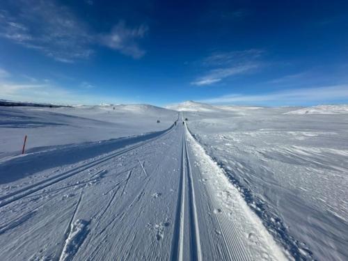 a road in the middle of a snow covered field at Orrelie by Norgesbooking - cabin with a lovely view in Ål