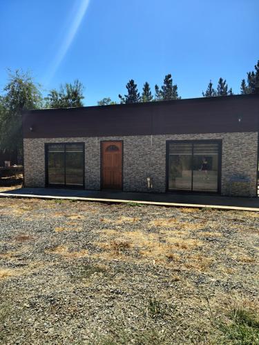 a brick building with a brown door and windows at Cabañas mi refugio salto del laja in Salto del Laja