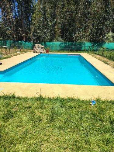 a large blue swimming pool in the grass at Cabañas mi refugio salto del laja in Salto del Laja