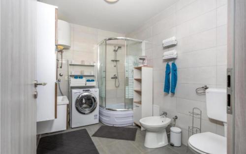 a bathroom with a toilet and a washing machine at Apartman M&L in Žgaljić