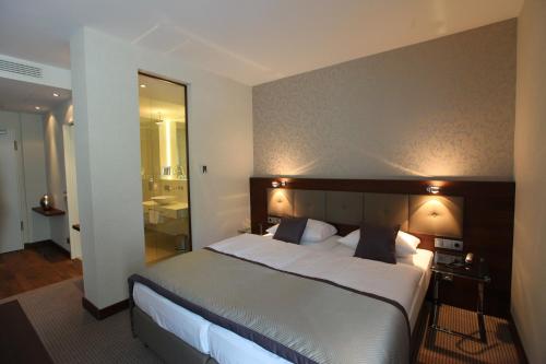 a bedroom with a large bed and a bathroom at Schlosshotel Kassel in Kassel