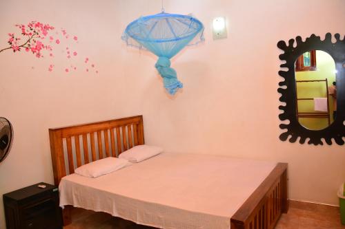 a room with a bed with a mirror and a bed sidx sidx sidx at Binara Home Stay in Polonnaruwa