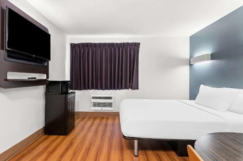 a hotel room with a bed and a flat screen tv at Econo Lodge in Idaho Falls