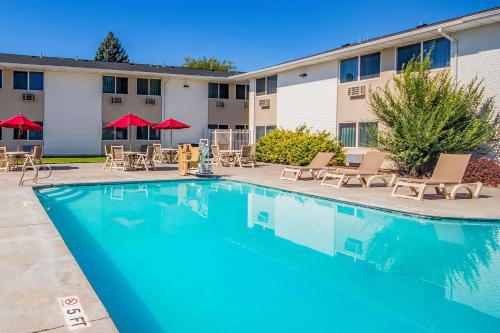 a pool with chairs and tables in front of a hotel at Econo Lodge in Idaho Falls