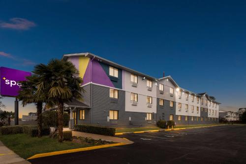a building with a palm tree next to a street at Spark by Hilton Norfolk in Norfolk