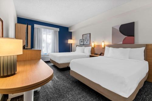 a hotel room with two beds and a desk at Spark By Hilton Hershey Near The Park in Hershey