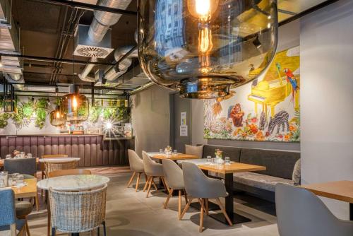 Un restaurante con mesas y sillas y un bar. en Vienna House Easy by Wyndham Hamburg Bergedorf, en Hamburgo