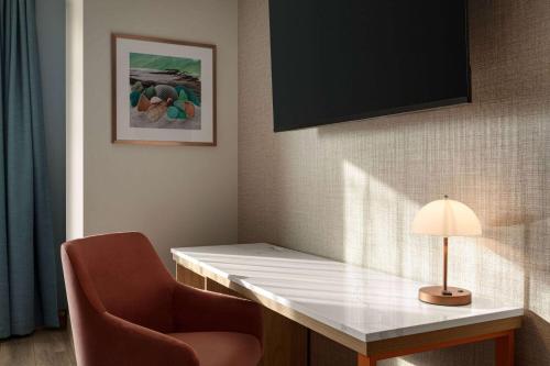 a room with a desk with a chair and a lamp at Sea Glass Beach Place, Trademark Collection by Wyndham in Fort Lauderdale