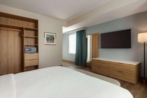 a hotel room with a bed and a flat screen tv at Sea Glass Beach Place, Trademark Collection by Wyndham in Fort Lauderdale