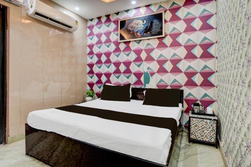 a bedroom with a bed and a pink wall at Super Hotel O Signature Plaza in New Delhi