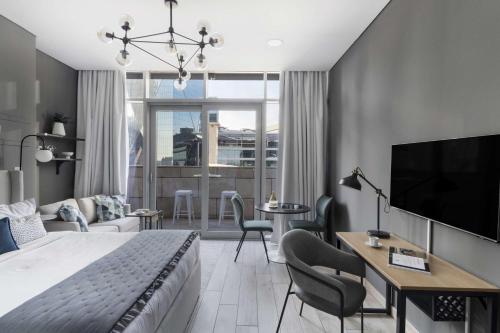 a bedroom with a bed and a desk and a tv at Silkhaus Dubai Financial Center studio in Burj Daman in Dubai