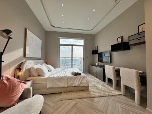 a bedroom with a bed and a desk and chairs at Warm and Elegant Studio in Dubai in Dubai