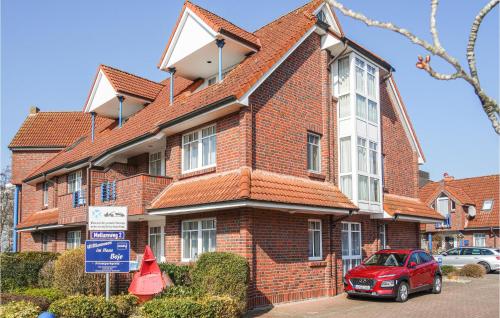 a red brick house with a car parked in front of it at Ferienwohnung Himmelsglueck in Wangerland