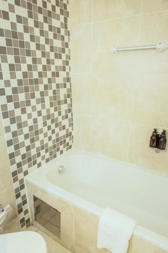 a bathroom with a bath tub and a toilet at Cresta Lodge Gaborone in Gaborone