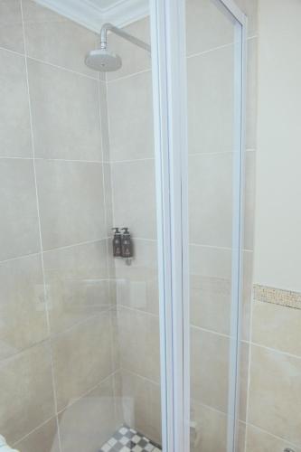 a bathroom with a shower with a glass door at Cresta Lodge Gaborone in Gaborone