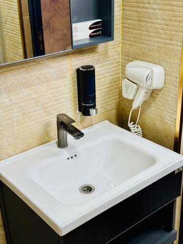 a bathroom sink with a hair dryer and a phone at Arda Plaza Hotel in Tashkent