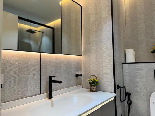 a bathroom with a sink and a mirror at Warm and Elegant Studio in Dubai in Dubai