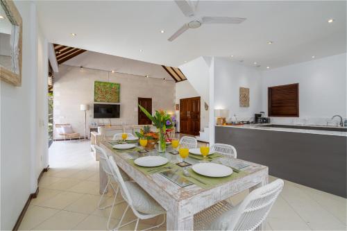a dining room and kitchen with a table and chairs at Villa Nolan - Modern 3BR Private Villa with Pool in Padonan, Canggu in Kerobokan