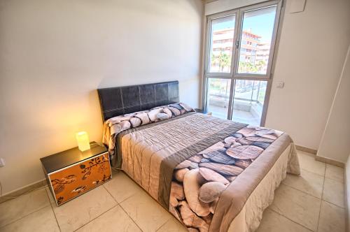 a bedroom with a large bed and a window at Valencia Beach Apartments in Valencia